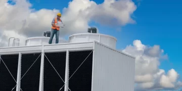 foto de torre de refrigeração com um trabalhador em inspeção