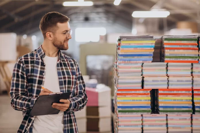 Homem anotando em fábrica de papel