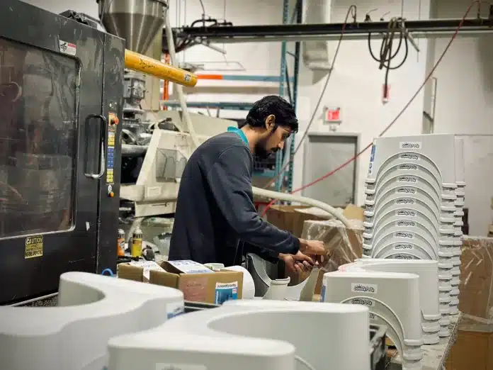 Homem em fábrica de peças plásticas